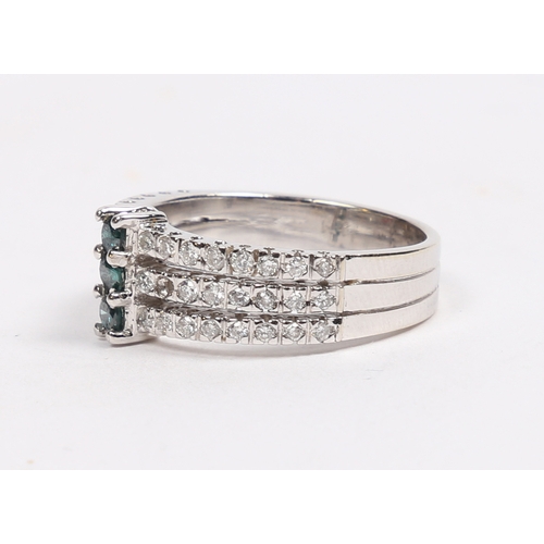 43 - A 14 CARAT WHITE GOLD, EMERALD AND DIAMOND RING. set with three central round cut emeralds flanked b... 