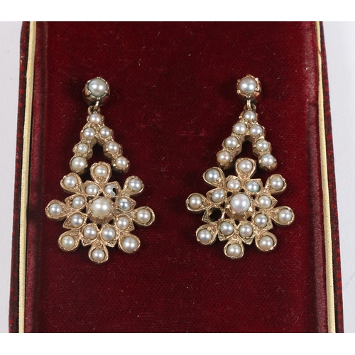 51 - A PAIR OF YELLOW METAL AND PEARL EARRINGS. the drops in the form of stylised flower heads, 38.5mm dr... 