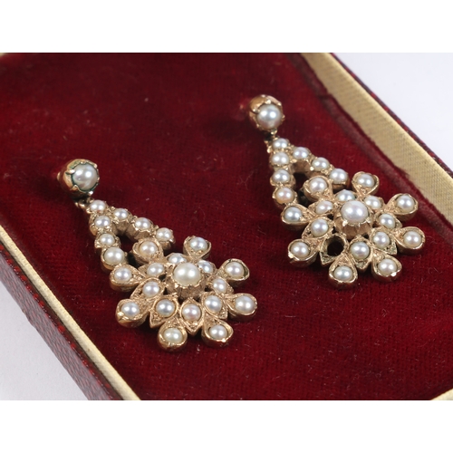 51 - A PAIR OF YELLOW METAL AND PEARL EARRINGS. the drops in the form of stylised flower heads, 38.5mm dr... 