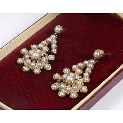 51 - A PAIR OF YELLOW METAL AND PEARL EARRINGS. the drops in the form of stylised flower heads, 38.5mm dr... 