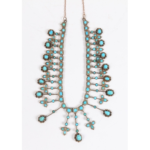 55 - A WHITE METAL AND TURQUOISE NECKLACE. formed from graduated stylised leaf and orb form drops, with l... 