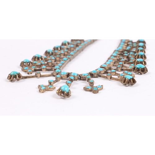 55 - A WHITE METAL AND TURQUOISE NECKLACE. formed from graduated stylised leaf and orb form drops, with l... 