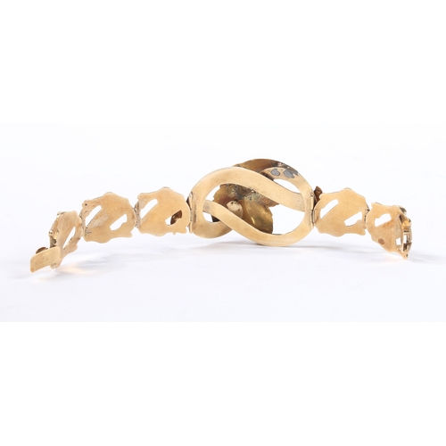 61 - A YELLOW METAL AND WHITE ENAMEL BRACELET. formed from pierced scroll and acanthus leaf links, the ce... 