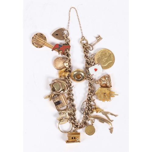 64 - A 9 CARAT GOLD CHARM BRACELET. set with 22 charms including a George V half sovereign 1907, cuckoo c... 