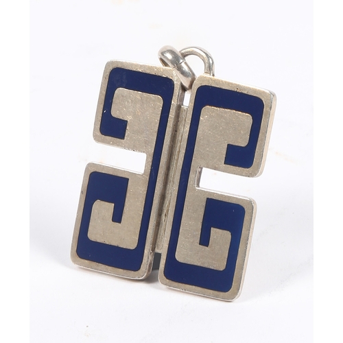 68 - A GUCCI SILVER AND BLUE ENAMEL PENDANT. modelled as two G's, hallmarked for London 1974, 39mm wide, ... 