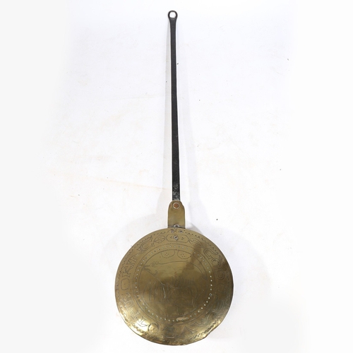 11 - A RARE CHARLES I BRASS AND IRON WARMING PAN, CIRCA 1640. The domed brass cover decorated with the in... 