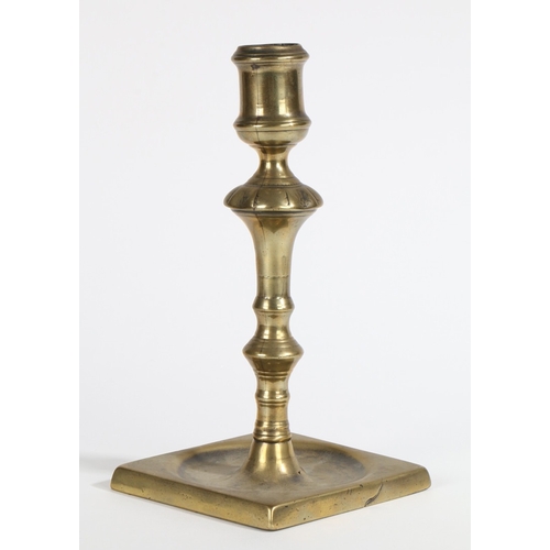 12 - A GEORGE II BRASS SOCKET CANDLESTICK, CIRCA 1740. Seamed and cast, with large cylindrical socket, an... 