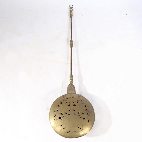 125 - A BRASS, IRON AND COPPER WARMING PAN, DUTCH, CIRCA 1700. The domed circular cover pierced and punch-... 