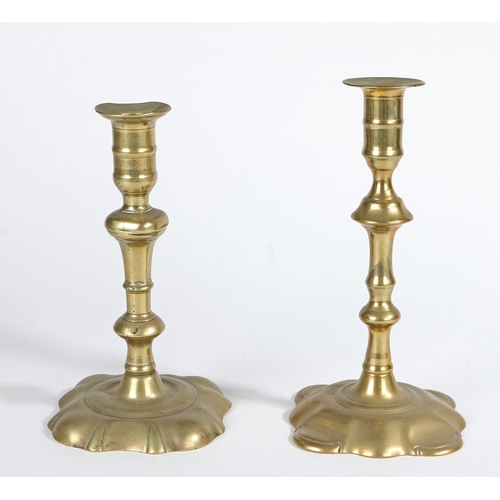 133 - TWO GEORGE II BRASS SOCKET CANDLESTICKS, CIRCA 1755. Seamed, each flanged socket with mid-fillet, an... 