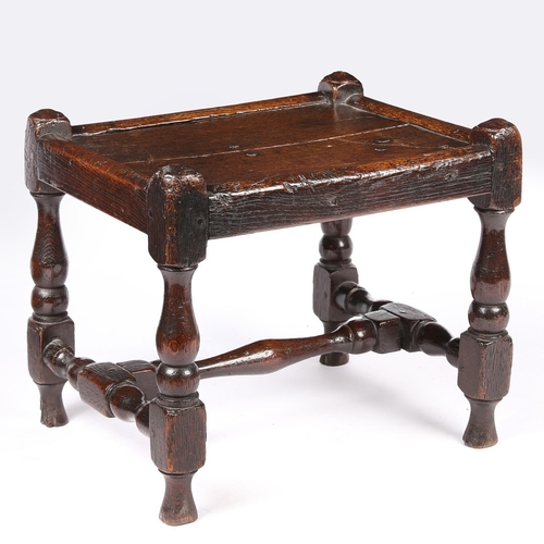 141 - AN UNCOMMON WILLIAM & MARY JOINED OAK STOOL, CIRCA 1690. Having a twin-boarded panelled seat, and di... 