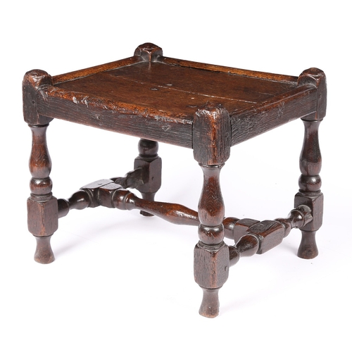 141 - AN UNCOMMON WILLIAM & MARY JOINED OAK STOOL, CIRCA 1690. Having a twin-boarded panelled seat, and di... 