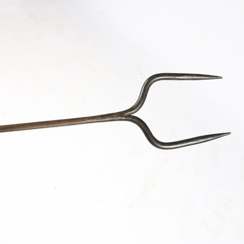 189 - AN 18TH CENTURY IRON LOG FORK, ENGLISH, CIRCA 1700-50. With two tines, the long round stem with two ... 