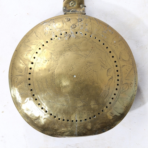 301 - A CHARLES I BRASS AND IRON WARMING PAN, CIRCA 1640. The circular brass cover decorated with the insc... 