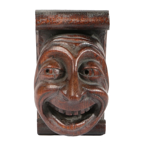 374 - AN AMUSING 15TH CENTURY OAK MASK CORBEL, ENGLISH. Designed as a bright-eyed male, his broad beaming ... 