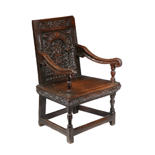 385 - A GOOD AND RARE ELIZABETH I OAK OPEN ARMCHAIR, CIRCA 1570. The back panel carved with a stylized flo... 