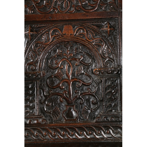 385 - A GOOD AND RARE ELIZABETH I OAK OPEN ARMCHAIR, CIRCA 1570. The back panel carved with a stylized flo... 