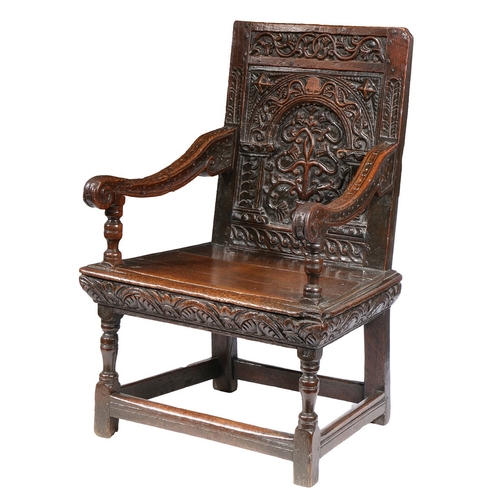 385 - A GOOD AND RARE ELIZABETH I OAK OPEN ARMCHAIR, CIRCA 1570. The back panel carved with a stylized flo... 