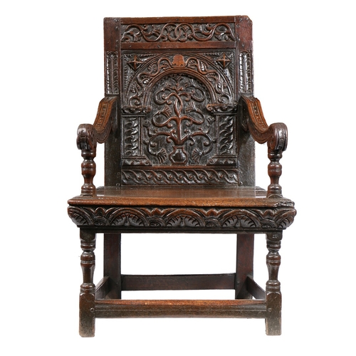 385 - A GOOD AND RARE ELIZABETH I OAK OPEN ARMCHAIR, CIRCA 1570. The back panel carved with a stylized flo... 