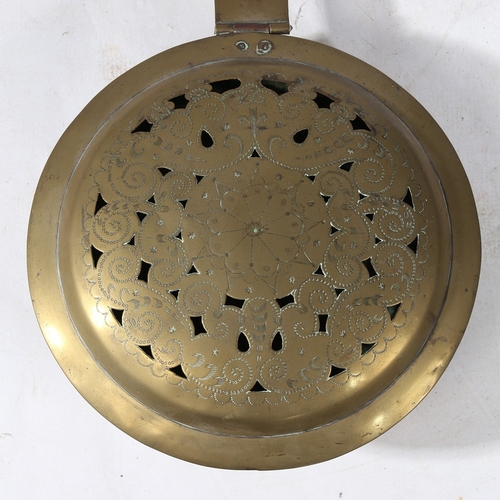 392 - A BRASS AND IRON WARMING PAN, DUTCH, CIRCA 1700. Having a pierced and punch-decorated cover, centred... 