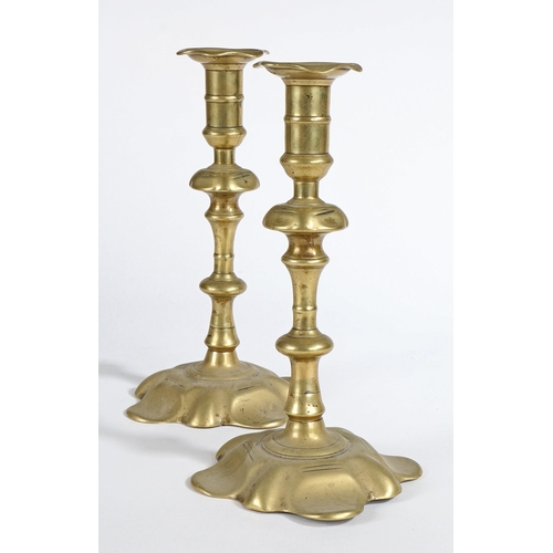 53 - A PAIR OF GEORGE II BRASS SOCKET CANDLESTICKS, CIRCA 1755. Each with an elongated and fillet centred... 