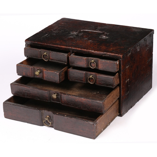 6 - AN UNUSUAL SMALL BOARDED OAK TABLE-TOP CHEST OF DRAWERS, ENGLISH, CIRCA 1700-20. With iron bale hand... 