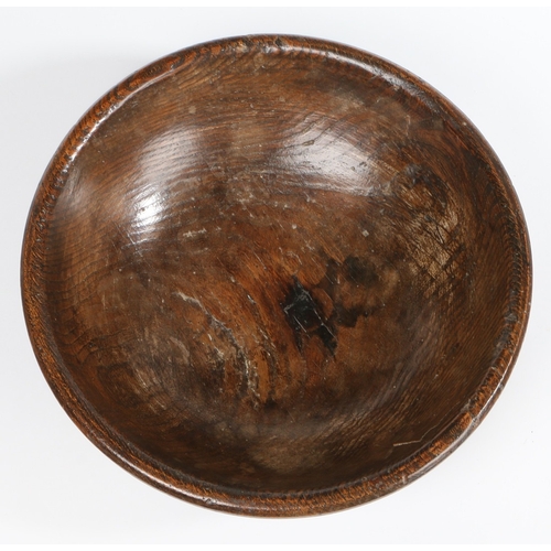 83 - A GEORGE III ELM TURNED DAIRY BOWL, CIRCA 1800. With decorative line turnings to exterior, including... 