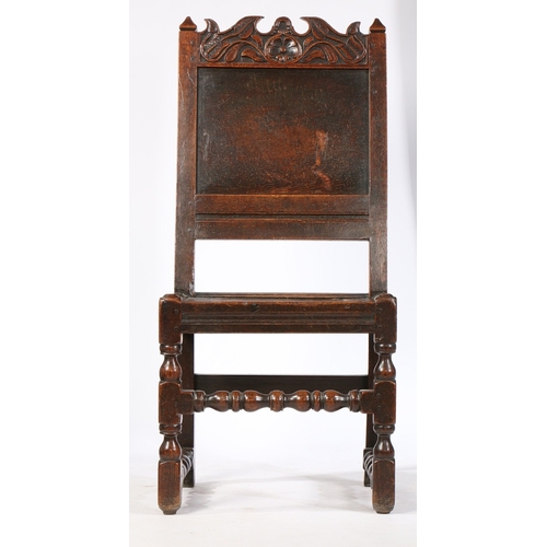 99 - A CHARLES II OAK BACKSTOOL, LANCASHIRE, CIRCA 1670. Having a plain back panel, a scroll-profiled and... 