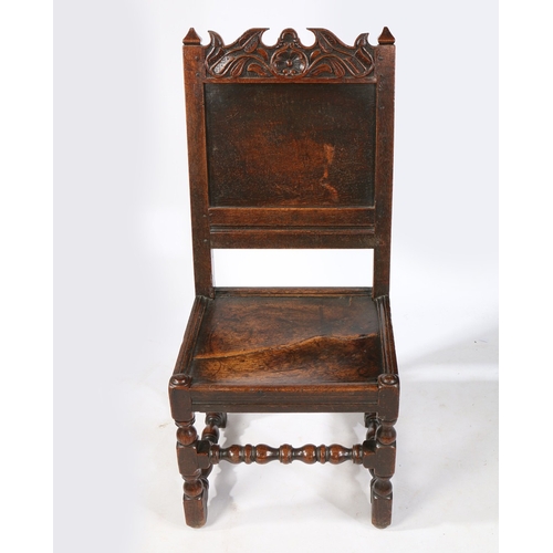 99 - A CHARLES II OAK BACKSTOOL, LANCASHIRE, CIRCA 1670. Having a plain back panel, a scroll-profiled and... 