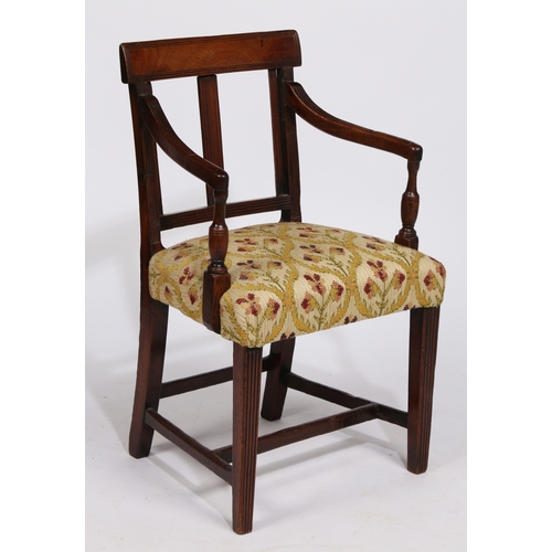 18 - A REGENCY MAHOGANY CHILDS ARMCHAIR. having a horizontal splat back raised on reeded arms on a uphols... 