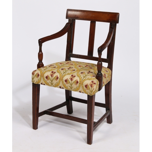 18 - A REGENCY MAHOGANY CHILDS ARMCHAIR. having a horizontal splat back raised on reeded arms on a uphols... 