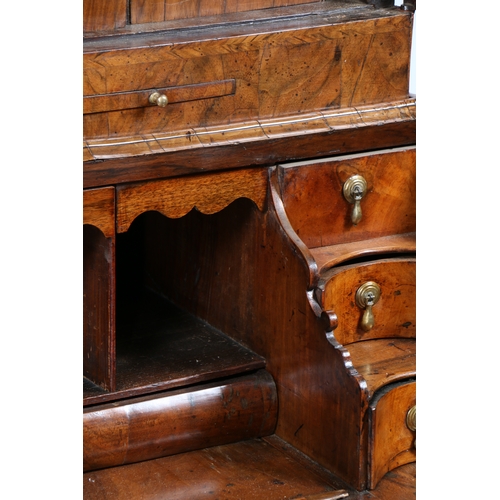 34 - A GEORGE I WALNUT DOUBLE DOME BUREAU BOOKCASE. Having a double domed bookcase with a pair of mirrore... 