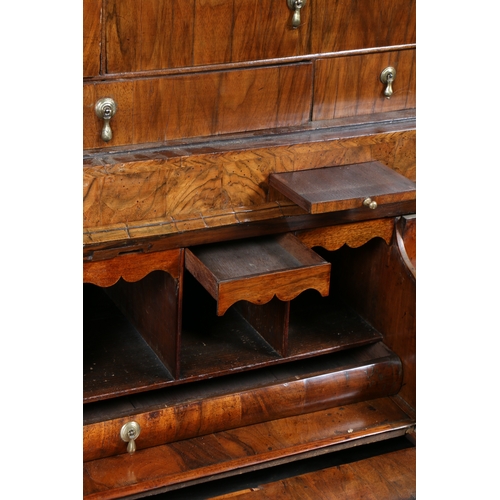 34 - A GEORGE I WALNUT DOUBLE DOME BUREAU BOOKCASE. Having a double domed bookcase with a pair of mirrore... 