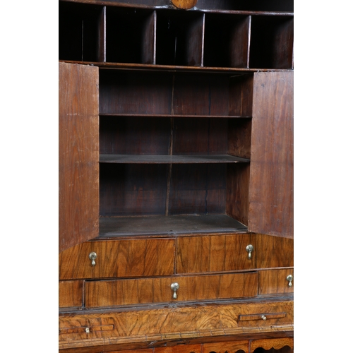 34 - A GEORGE I WALNUT DOUBLE DOME BUREAU BOOKCASE. Having a double domed bookcase with a pair of mirrore... 