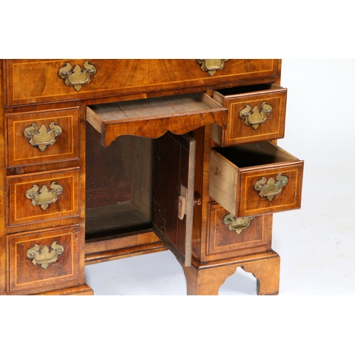 81 - A QUEEN ANNE WALNUT KNEEHOLE DESK. having a cross banded top with shaped corners above seven cross b... 