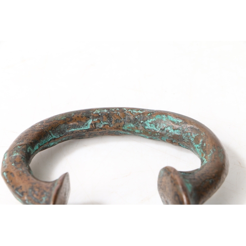 21 - AN AFRICAN BRONZE TRADE TORC OR BANGLE. of typical form, 8cm wide.