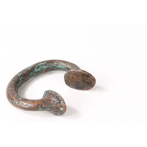 21 - AN AFRICAN BRONZE TRADE TORC OR BANGLE. of typical form, 8cm wide.