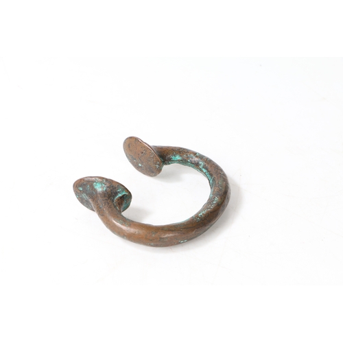 21 - AN AFRICAN BRONZE TRADE TORC OR BANGLE. of typical form, 8cm wide.