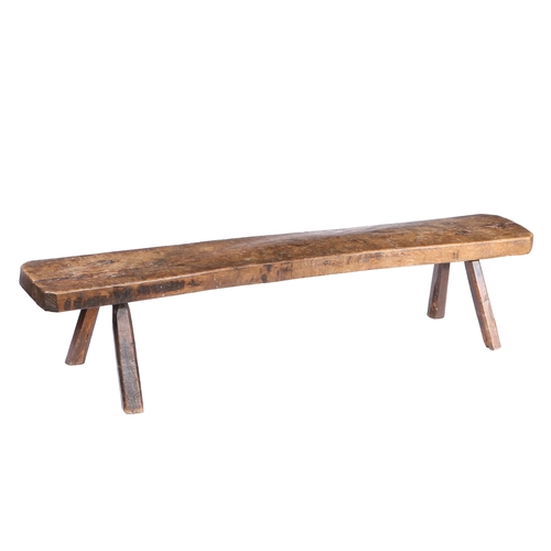 13 - A 19TH CENTURY OAK PIG BENCH. The long rectangular top above angled canted legs, 153cm long, 31cm wi... 