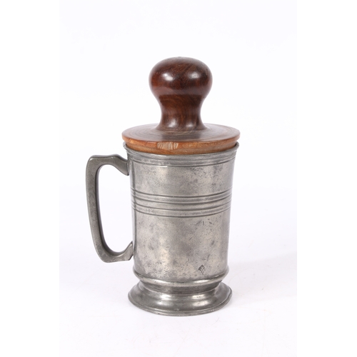 153 - AN EARLY 19TH CENTURY LIGNUM VITAE 'FORMER OR JACK AND A PEWTER QUART MUG. The straight-sided mug w... 