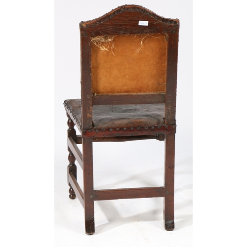 182 - A 17TH CENTURY OAK AND HIDE UPHOLSTERED SIDE CHAIR, LONDON. Having a serpentine-arched padded back, ... 