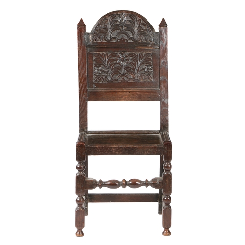 191 - A CHARLES II OAK BACKSTOOL, CIRCA 1670. With distinctive large arched floral and leaf-carved crestin... 