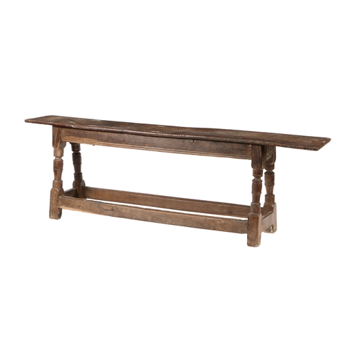 200 - A CHARLES I OAK FORM OR LONG BENCH, CIRCA 1640. The seat with moulded long edges and chip carved end... 