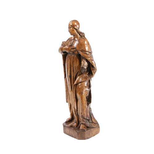 204 - A LARGE 17TH CENTURY WALNUT CARVED FIGURE. With long flowing hair below a skull cap, wearing a cape ... 