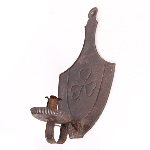 232 - A SHEET IRON WALL SCONCE, CIRCA 1820-50. The urn-shaped backplate centred by a repouseé triple-heart... 