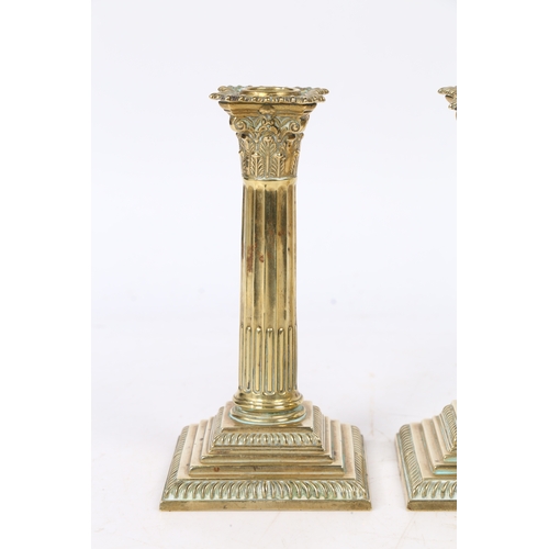 241 - A PAIR OF GEORGE III NEO-CLASSICAL BRASS CANDLESTICKS. with a Corinthian capital above a stop fluted... 