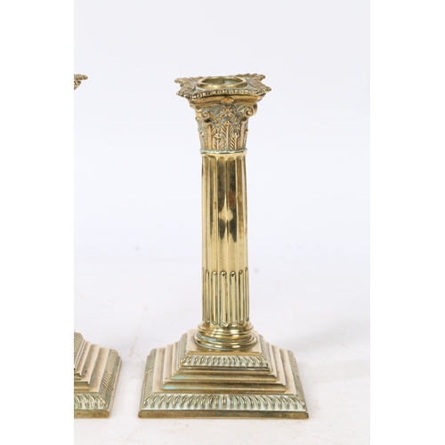 241 - A PAIR OF GEORGE III NEO-CLASSICAL BRASS CANDLESTICKS. with a Corinthian capital above a stop fluted... 