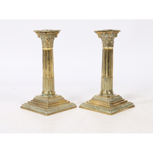 241 - A PAIR OF GEORGE III NEO-CLASSICAL BRASS CANDLESTICKS. with a Corinthian capital above a stop fluted... 