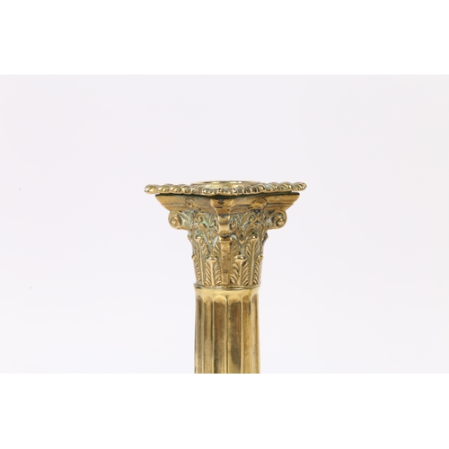 241 - A PAIR OF GEORGE III NEO-CLASSICAL BRASS CANDLESTICKS. with a Corinthian capital above a stop fluted... 