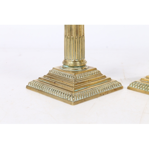 241 - A PAIR OF GEORGE III NEO-CLASSICAL BRASS CANDLESTICKS. with a Corinthian capital above a stop fluted... 