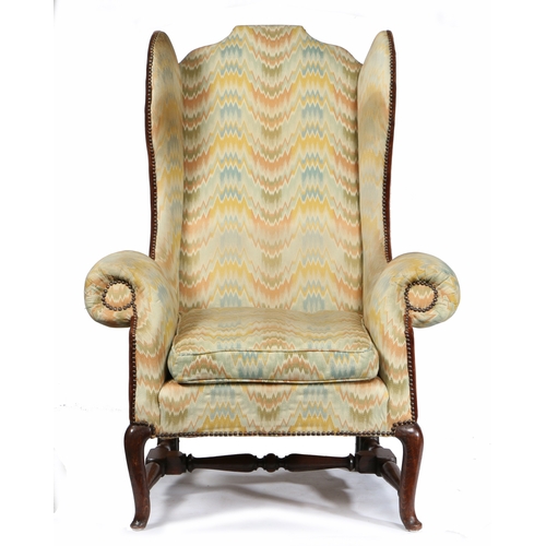 38 - A GEORGE I/II OAK AND UPHOLSTERED WING ARMCHAIR, CIRCA 1730. The padded flat-arched back, downswept ... 